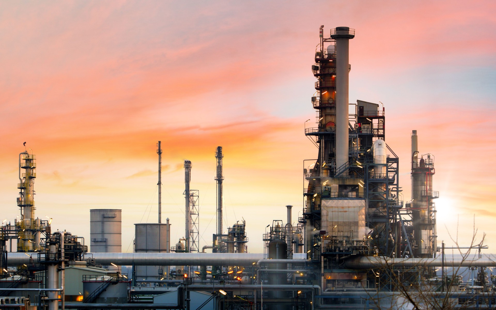 Oil refinery and plant and tower column of Petrochemistry industry in oil and gas industrial with cloud orange sky the sunrise background